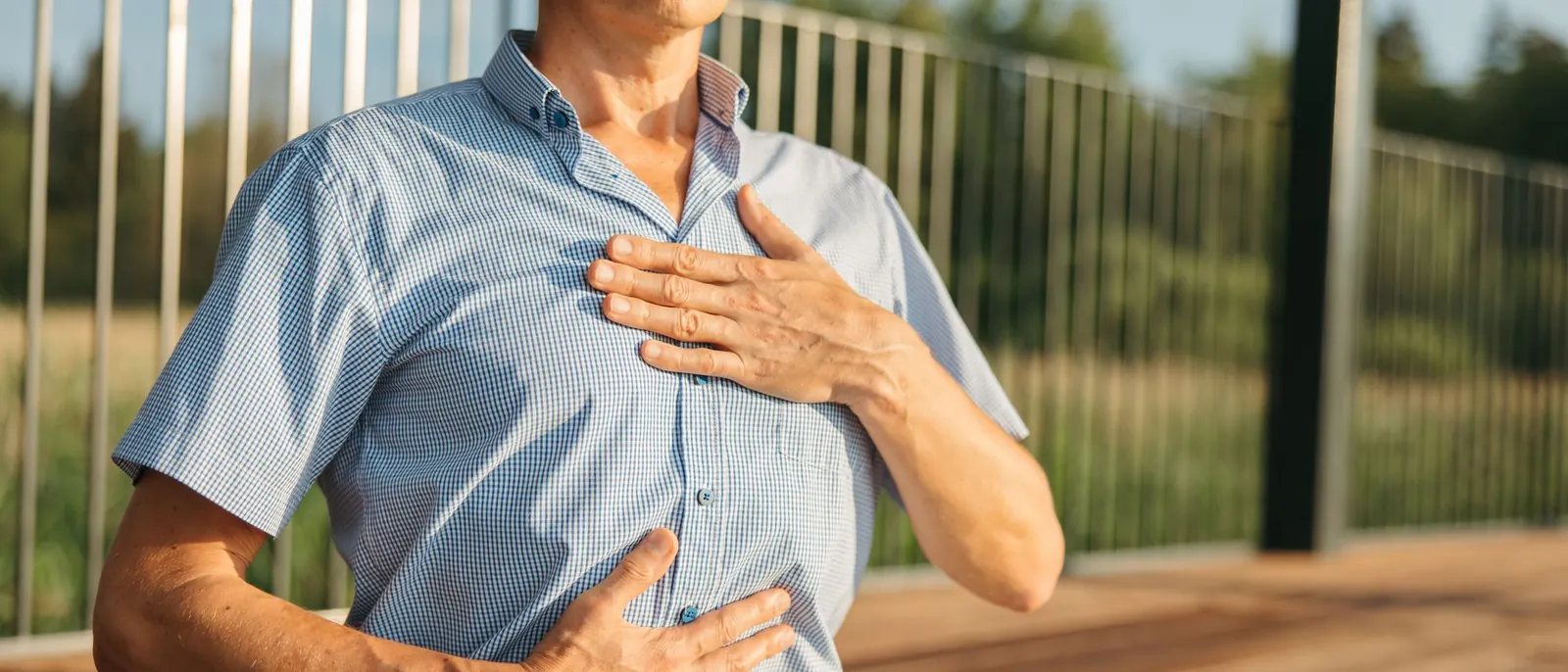 A man with one hand on his chest and one on his belly, breathing slowly