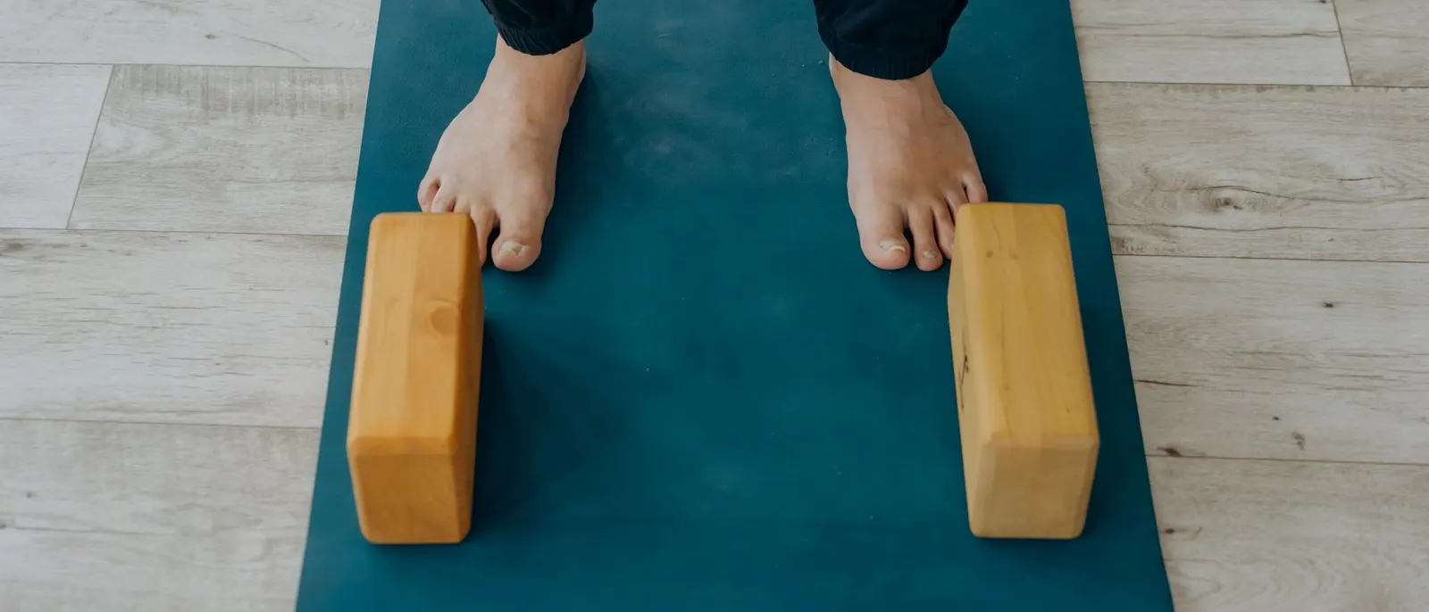 Bare feet on a yoga mat between two cork blocks