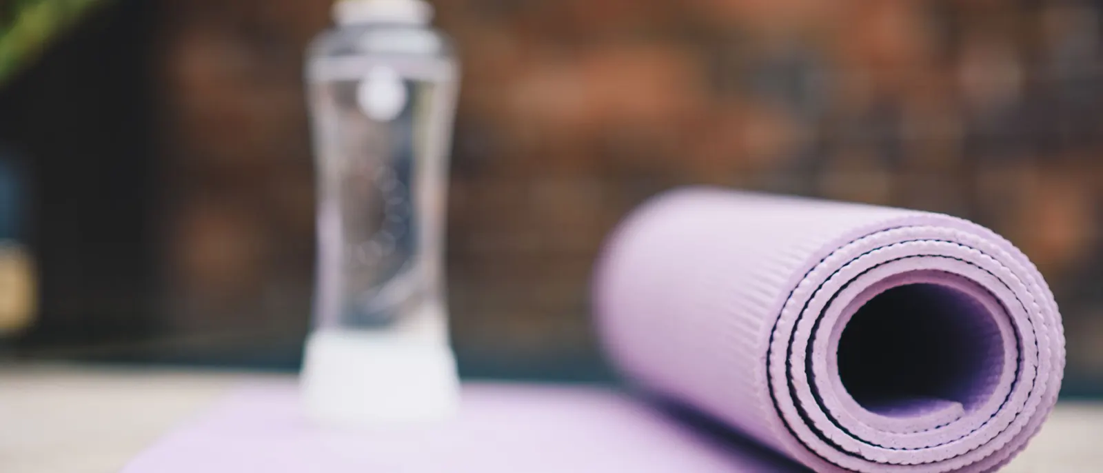 A rolled yoga mat and a water bottle