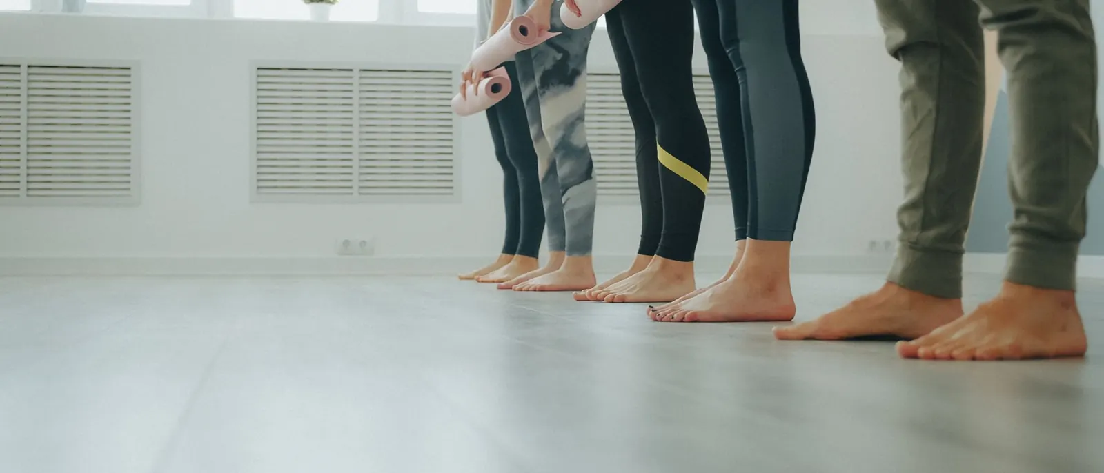 A row of students standing barefoot at the start of a class