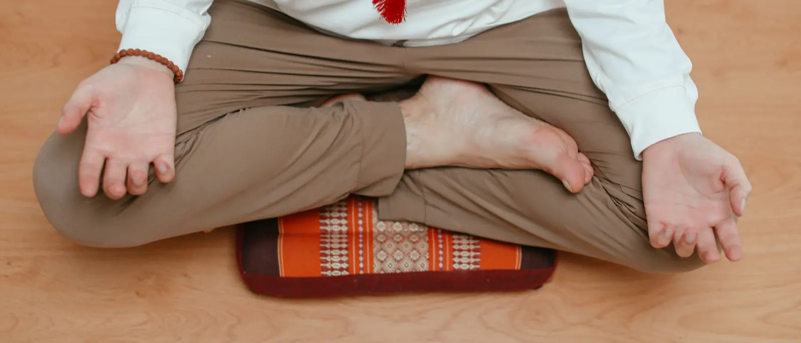 Overhead view of a person sitting cross-legged on a meditation cushion